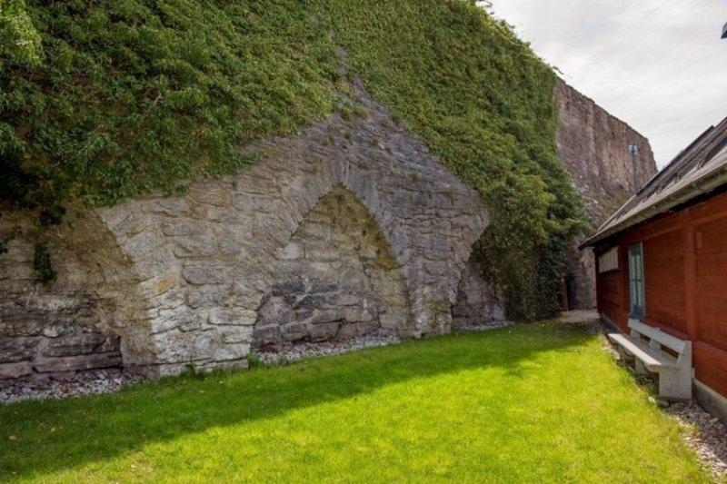 Kale duvarları arasına sıkışmış minik ev 