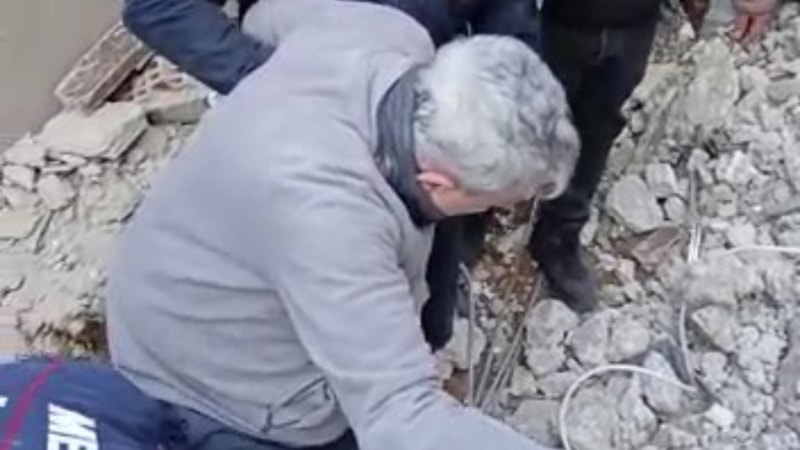 Kahramanmaraş'taki itfaiye eri, enkazın altından sağ çıkarılan adama botlarını giydirdi