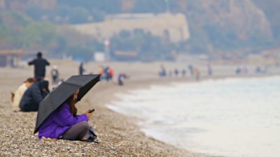 Antalya'da yağmura rağmen şemsiye altında deniz keyfi