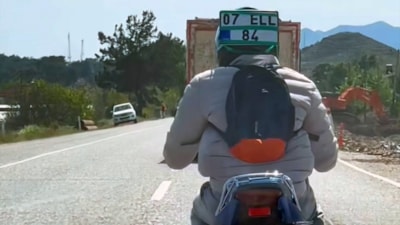 Muğla'da motosikletinden düşen plakayı kaskına taktı