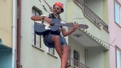 Bursa'da eşyalarını taşıdığı halatın üzerinde gitar çalıp, şarkı söyledi