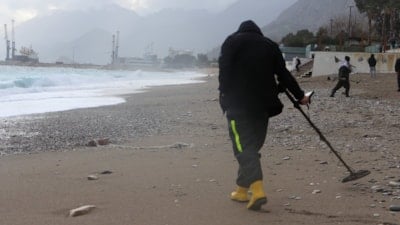 Antalya'da fırtınaya rağmen define avcıları, dedektörle arama yaptı