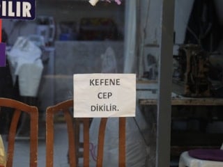 Hatay'da terzi işleten esnaf, camına 'kefene cep dikilir' yazdı