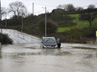 İstanbul'da göle dönen yolda mahsur kaldı: Arabasıyla beraber kurtarıldı