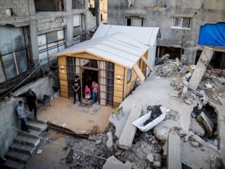 Gazze'de yıkılan evinin enkazı üzerinde barınak kurdu