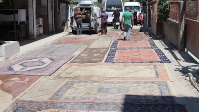 Adana'da asfaltlanmayan yolun tozundan rahatsız olan mahalleli halı serdi