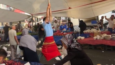 İstanbul'da kuvvetli rüzgarda branda direğini bırakmayan pazarcı kamerada