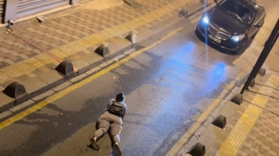 İstanbul'da bir kadın yola yüzüstü yatarak telefonuyla ilgilendi