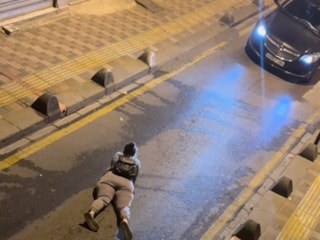 İstanbul'da bir kadın yola yüzüstü yatarak telefonuyla ilgilendi