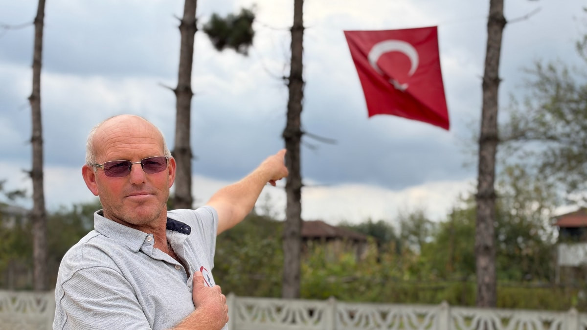 Düzce'de önce makinenin üzerine çıkıp Türk bayrağını düzeltti