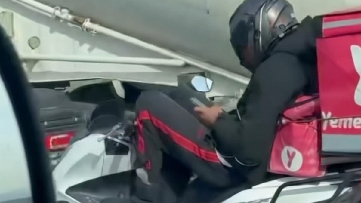 İstanbul’da kurye motosikletini bacaklarıyla kullanıp cep telefonuyla oynadı