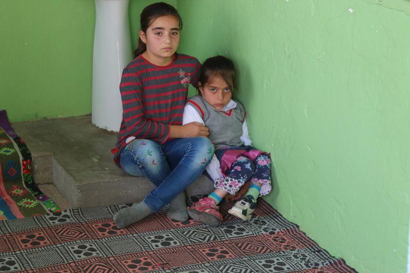 Sivaslı küçük kız yürüyemeyen kuzenini kucağında taşıyor