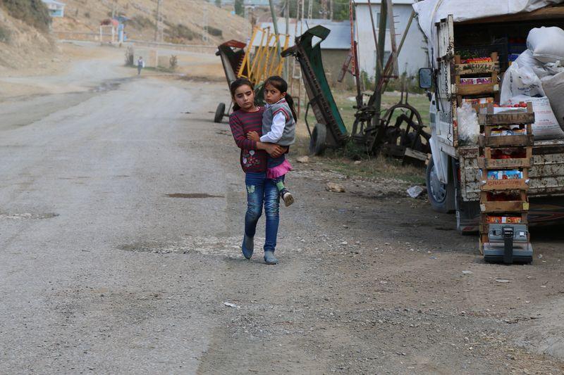 Sivaslı küçük kız yürüyemeyen kuzenini kucağında taşıyor