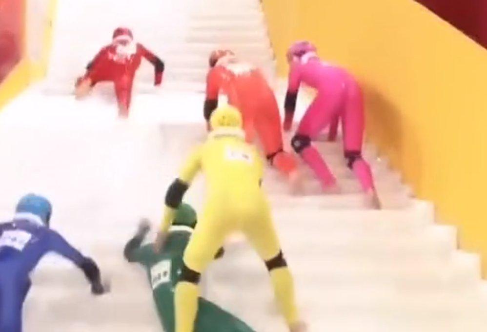 Kaygan merdivenleri tırmanmaya çalışan yarışmacılar