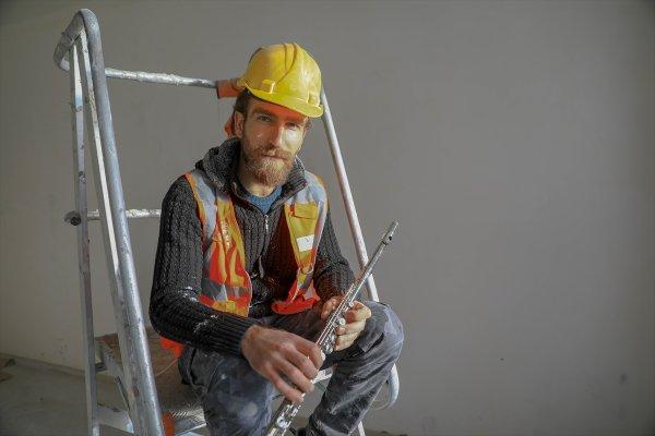 Yan flüt çalan inşaat işçisi