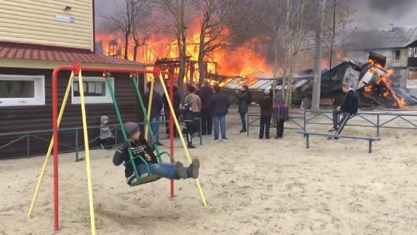 Arkasında ev yanarken eğlenen Rus çocuk