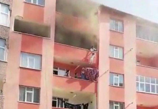 Çocukları yangından alt kata sarkıtarak kurtardı