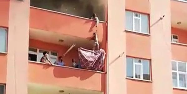 Çocukları yangından alt kata sarkıtarak kurtardı