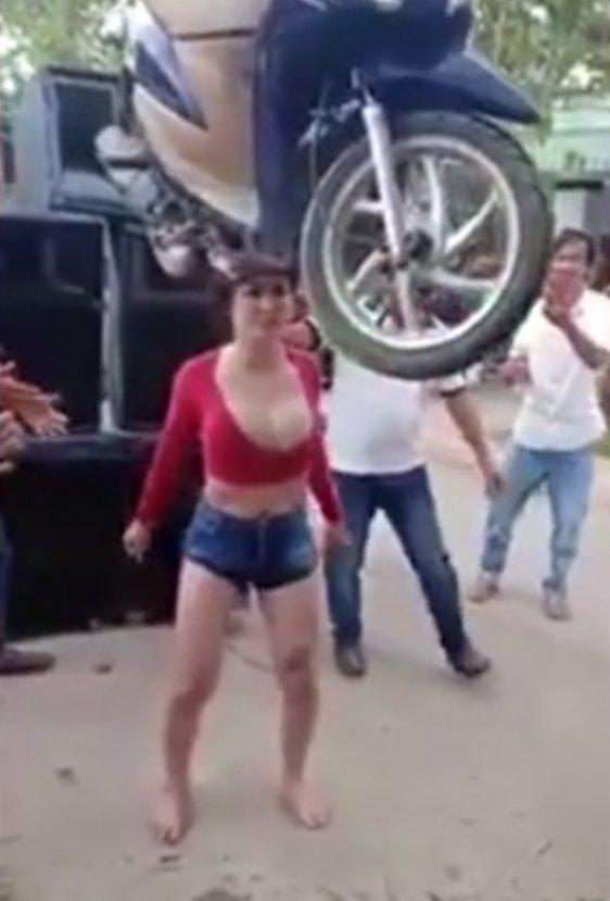 Asyalı genç kadın kafasında scooter taşıdı