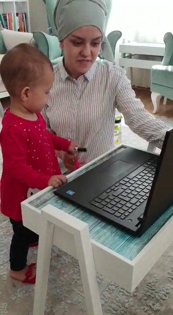 Öğrencilere ders anlatırken çocuğuyla da ilgilenen öğretmen