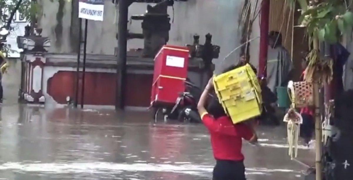 Bali'de bir çalışan, sular altında kalan yolda çukura düştü