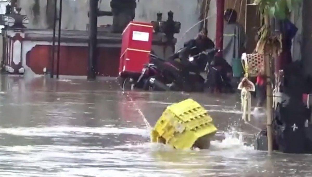 Bali'de bir çalışan, sular altında kalan yolda çukura düştü