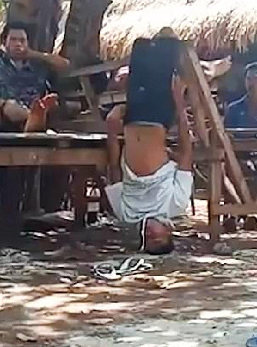 Endonezya’da bir aile, kızlarıyla izinsiz aynı evde kalan genci bacaklarından astı