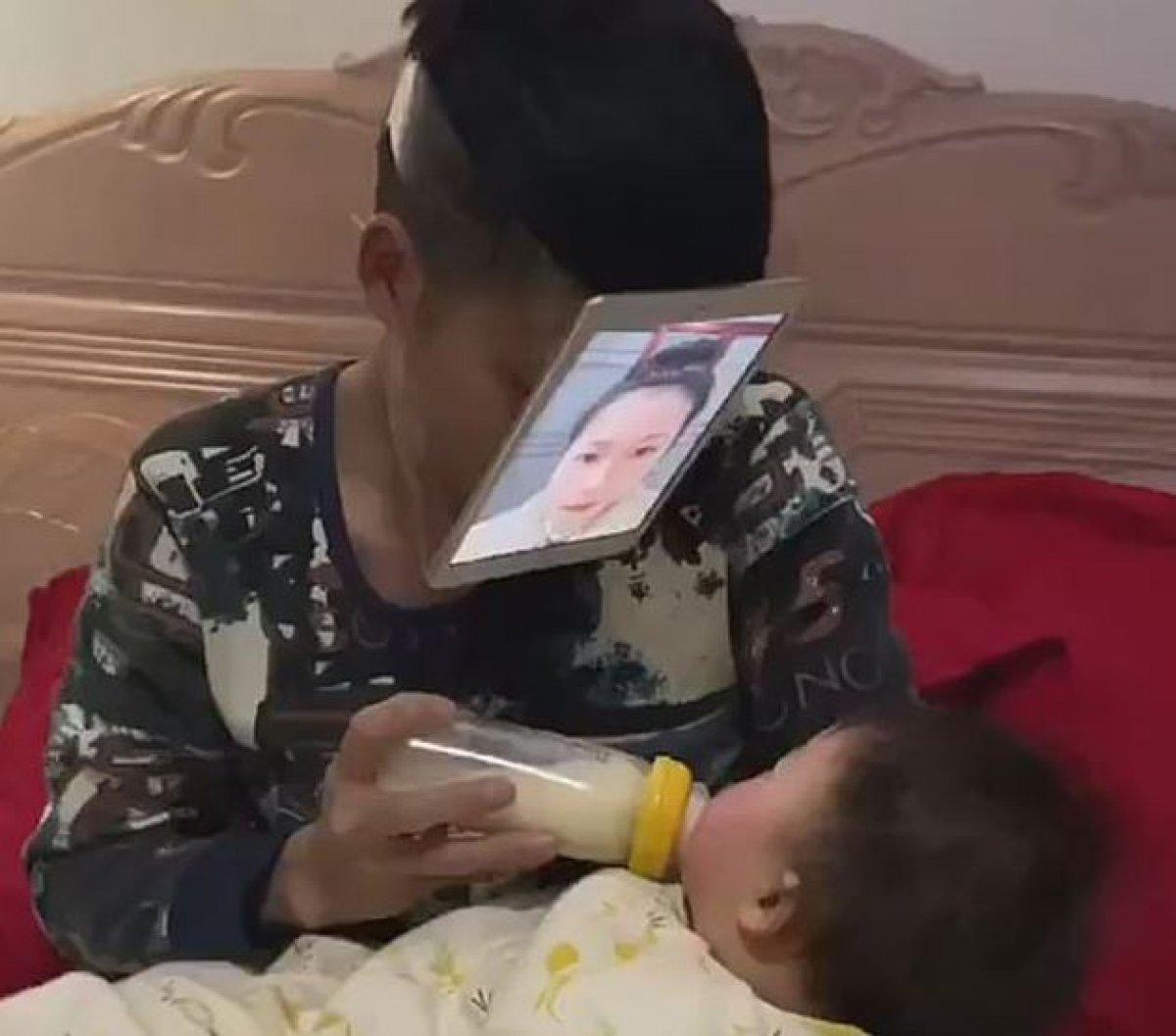 Çinli baba, yüzüne tablet takarak bebeğine süt içirdi