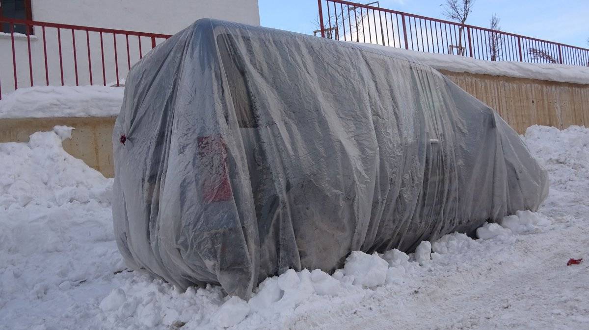 Yüksekova’da buz tutan araçları naylonla kapladılar