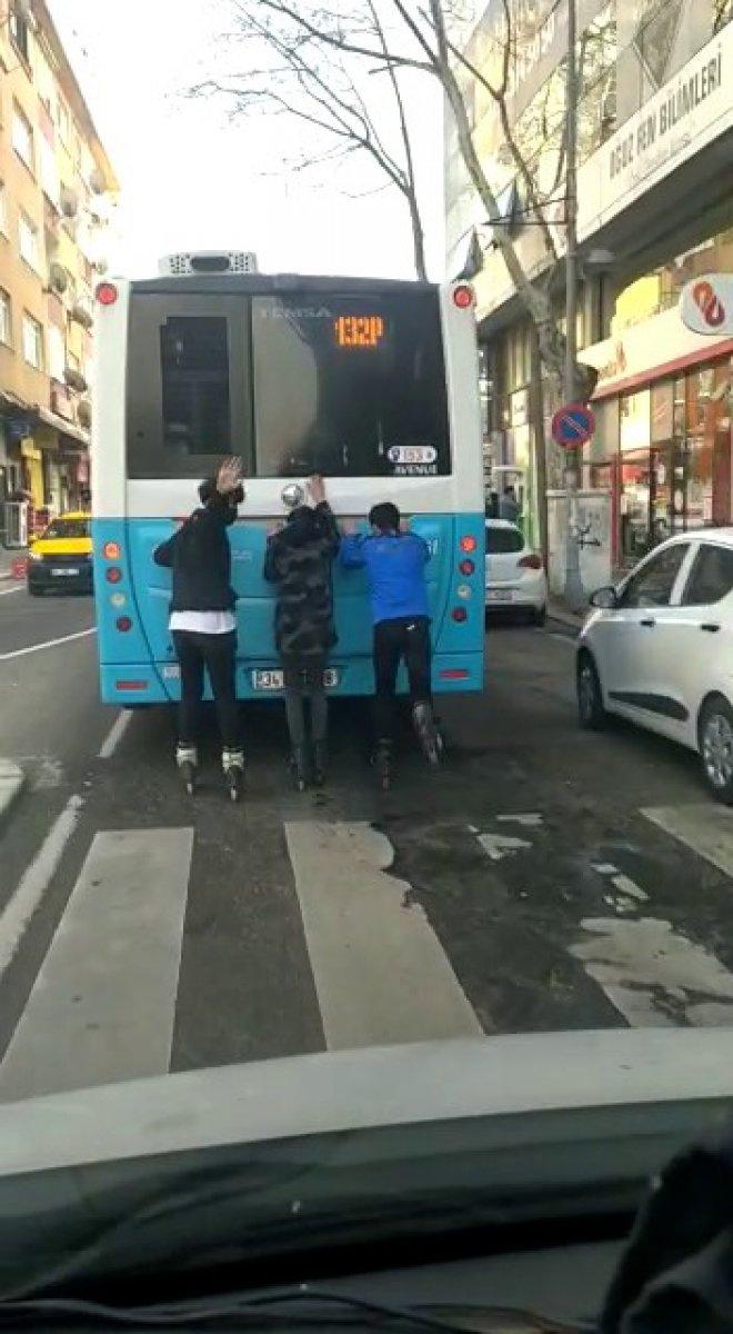 Kartal'da patenli 3 genç, otobüse tutunarak ilerledi