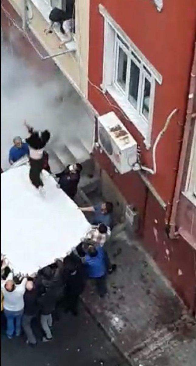 Esenler'de çıkan yangında mahsur kalan aile, çarşafla kurtarıldı