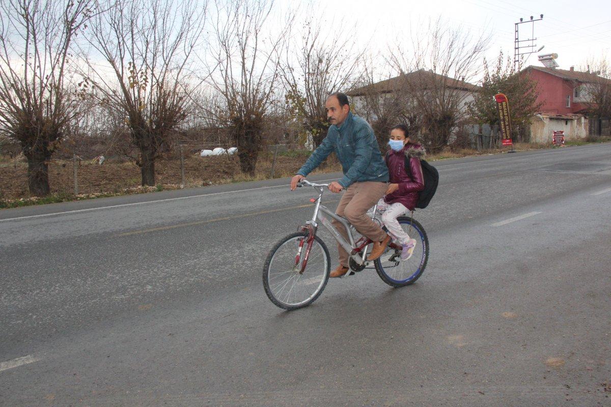 Malatya'daki baba, yürüyemeyen kızını bisikletle okula taşıyor