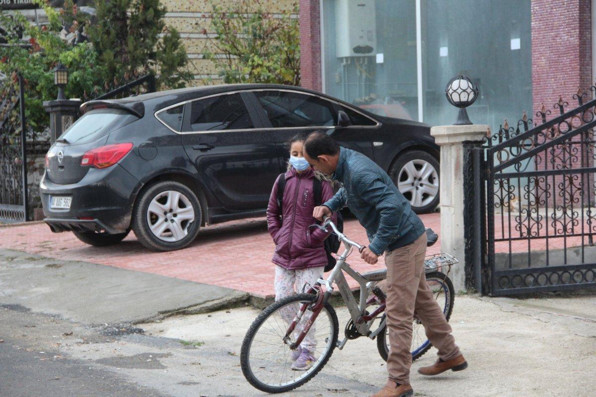 Malatya'daki baba, yürüyemeyen kızını bisikletle okula taşıyor