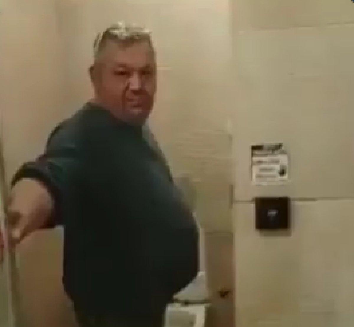 Benzinlikte şeffaf kapılı tuvaletin kapısına isyan eden adam