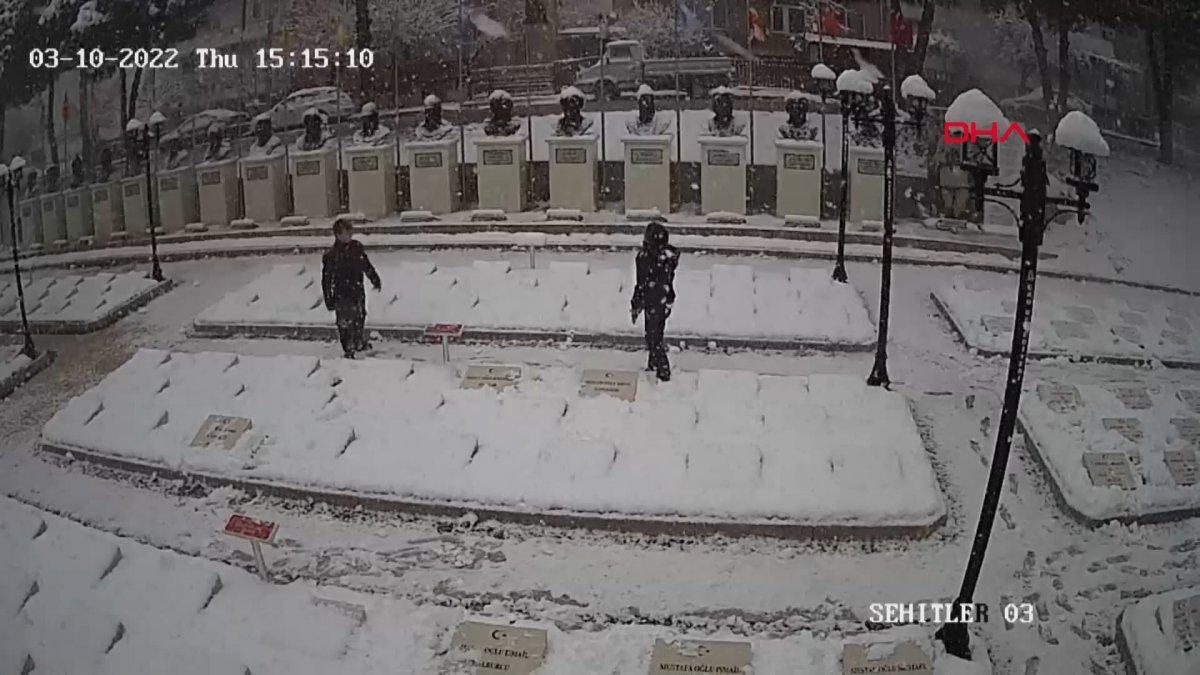 Çanakkale'de 2 genç, beyaza bürünen şehitlikteki mezar taşlarını temizledi