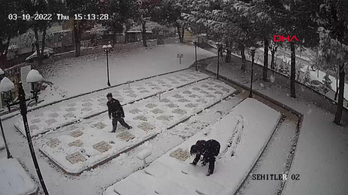 Çanakkale'de 2 genç, beyaza bürünen şehitlikteki mezar taşlarını temizledi