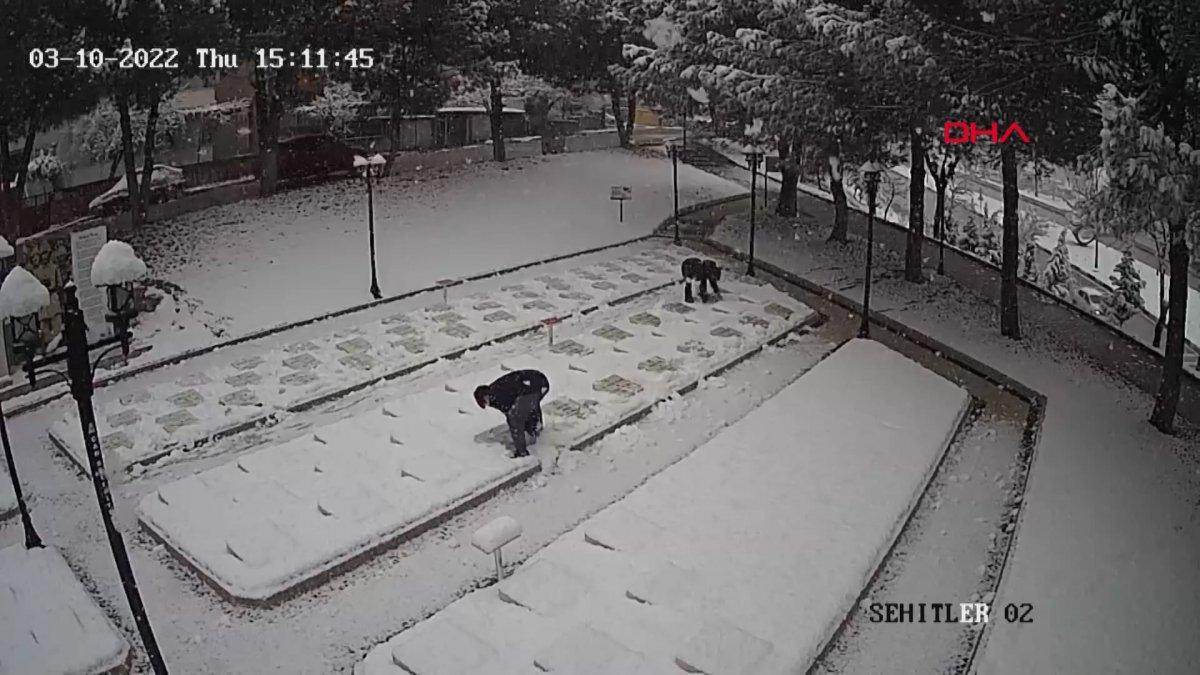 Çanakkale'de 2 genç, beyaza bürünen şehitlikteki mezar taşlarını temizledi