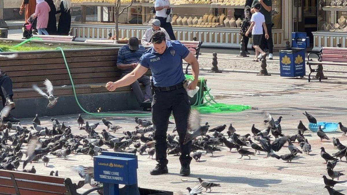 İstanbul'da bir polis memuru, güvercinleri ekmek kırıntıları ile besliyor