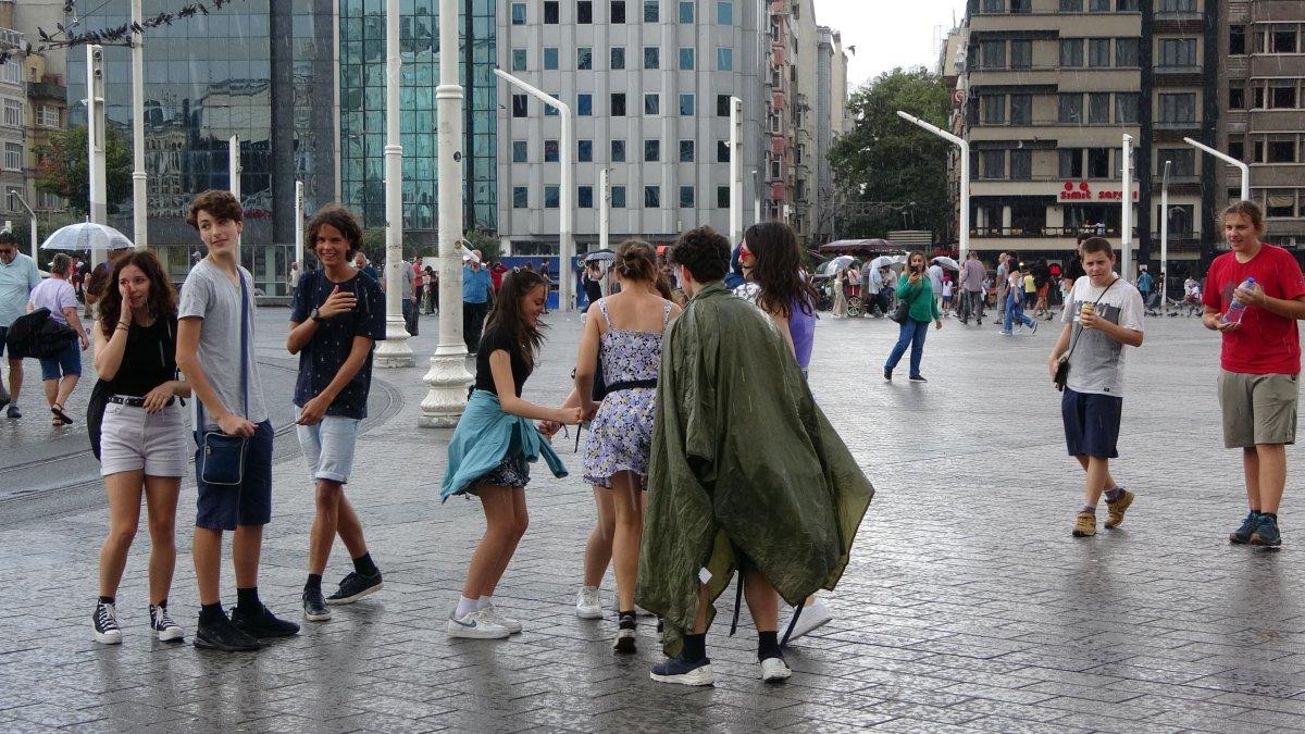 Taksim'de bir grup genç yağmurun altında dans etti